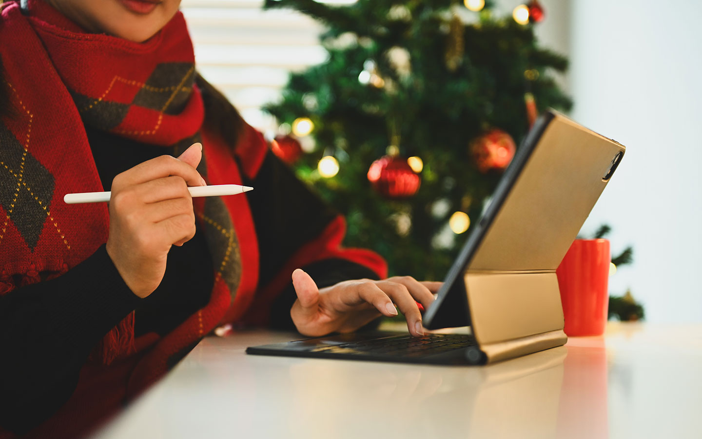 Person working on laptop with Christmas tree