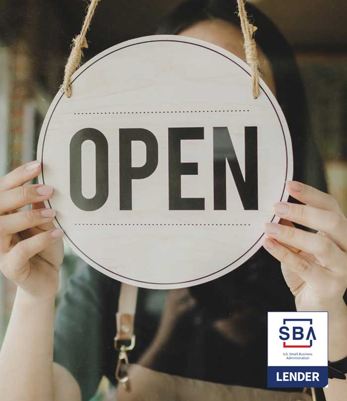 Business owner hanging open sign