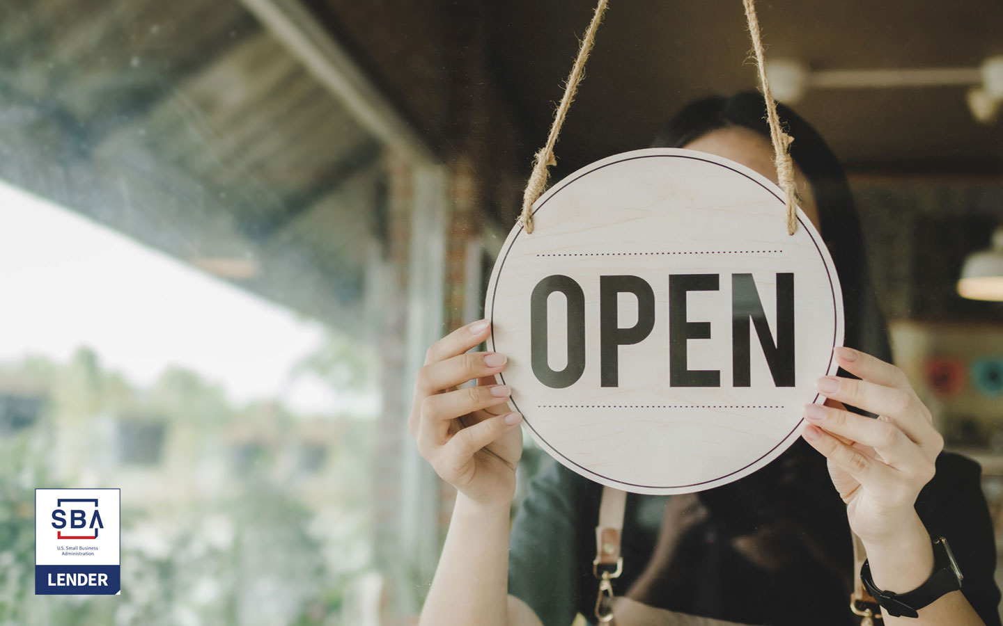 Business owner hanging open sign