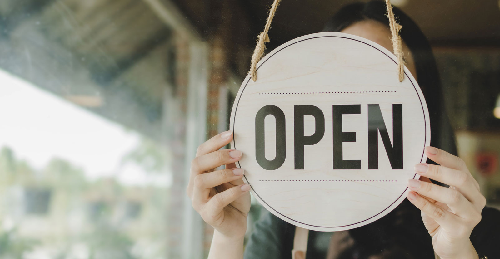 Business owner hanging open sign