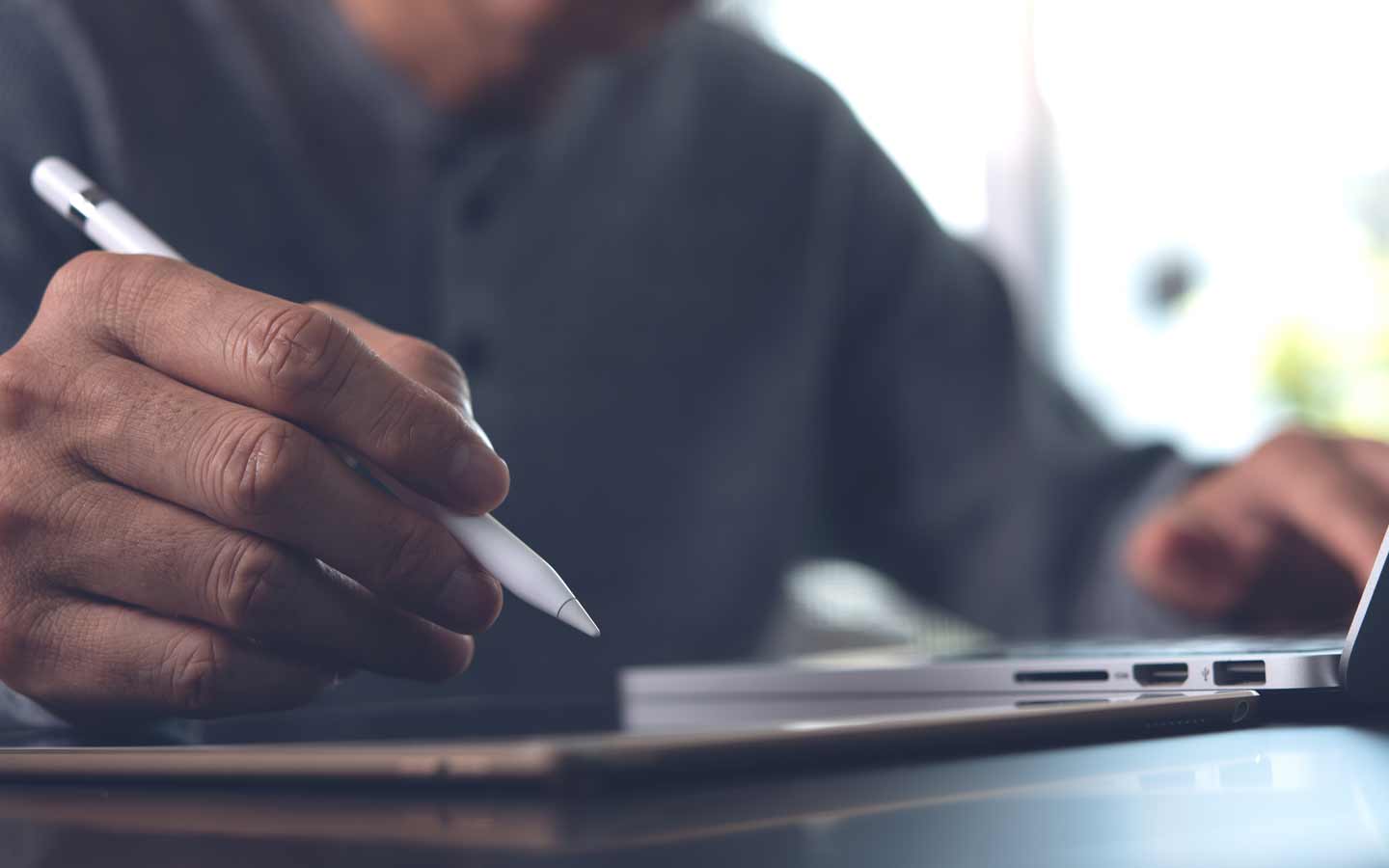 Man working on tablet and laptop